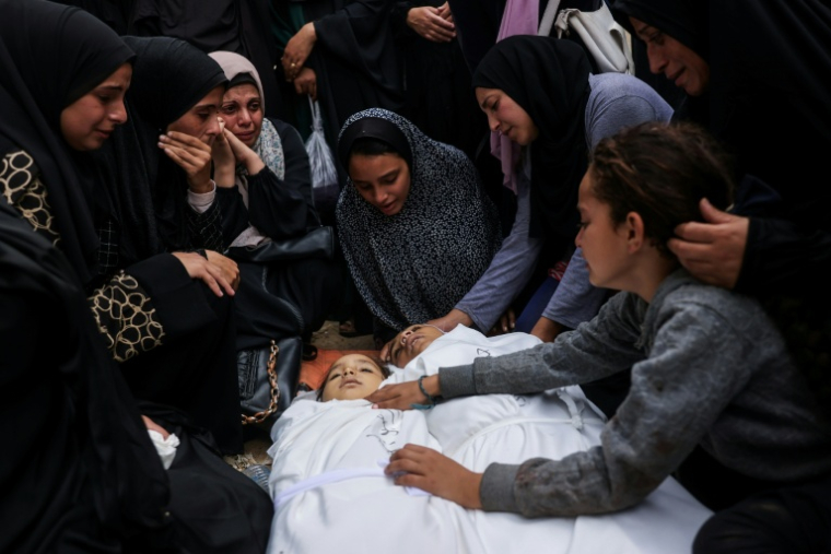 Des proches veillent les corps de deux enfants tués dans une frappe israélienne, le 29 octobre 2025 à Nousseirat, dans le centre de la bande de Gaza ( AFP / BASHAR TALEB )