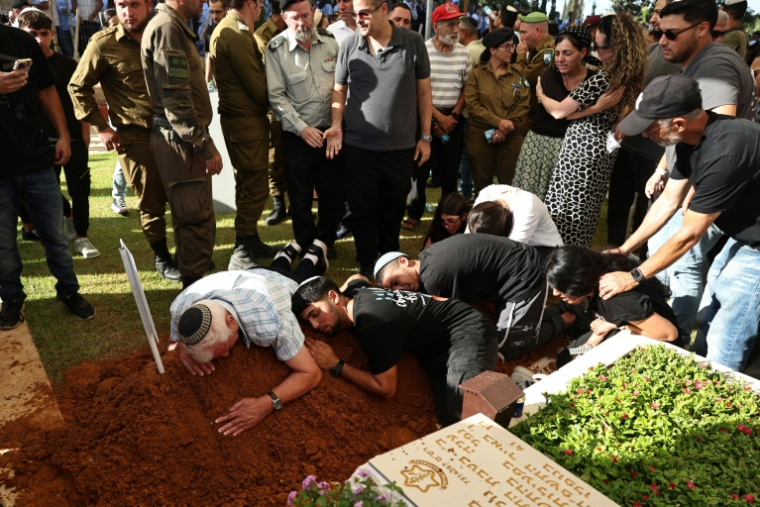 Des proches pleurent sur la tombe d'un soldat israélien tué dans la bande de Gaza, lors de ses funérailles à Rehovot, au sud de Tel-Aviv, le 25 juin 2026 ( AFP / Fadel SENNA )