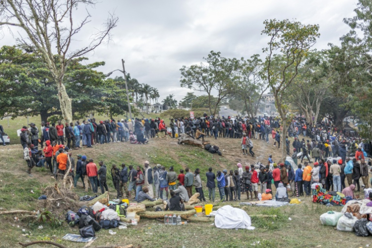 Des centaines d'étrangers fuyant les violences antimigrants font la queue pour recevoir de la nourriture dans le camp de fortune de Sherwood Park à Durban (Afrique du Sud), le 16 juin 2026 ( AFP / RAJESH JANTILAL )