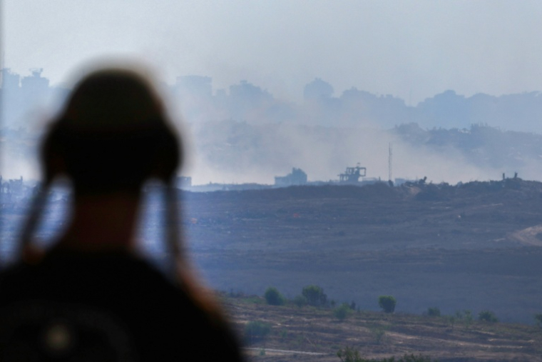 Un homme à un point de vue dans le sud d'Israël, surplombant la bande de Gaza, regarde la fumée s'élever pendant les frappes israéliennes sur la capitale assiégée le 15 juillet 2025 ( AFP / Jack GUEZ )