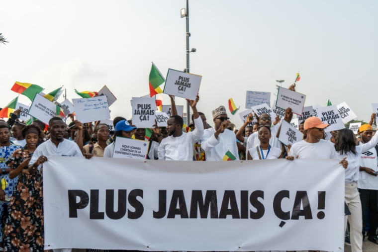 Des partisans du président du Bénin Patrice Talon tiennent une banderole durant un rassemblement de soutien au chef de l'Etat le 10 décembre 2025 à Cotonou ( AFP / Yanick Folly )