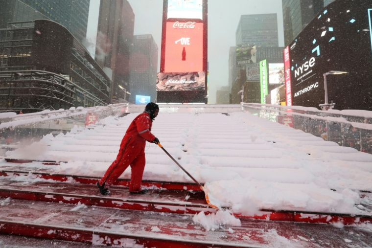 Une personne dégage la neige à Times Square, lors d'une tempête à New York, le 23 février 2026 ( AFP / TIMOTHY A.CLARY )