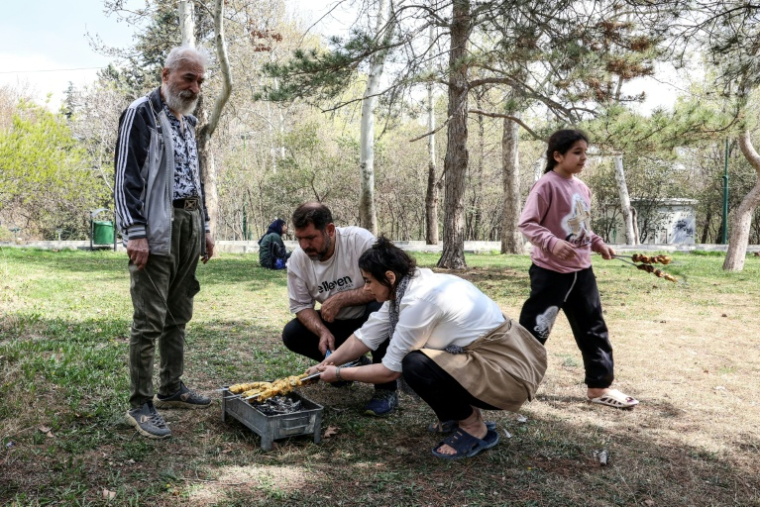 Des Iraniens préparent un barbecue au parc Mellat de Téhéran, le 2 avril 2026, à l'occasion de la "Journée de la nature "marquant la fin des festivités du Nouvel an persan ( AFP / - )
