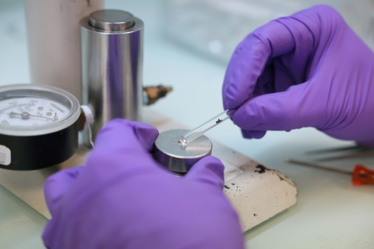 Un technicien presse des échantillons de graphite dans une cathode en aluminium afin d’éviter toute contamination avant le processus de mesure, au laboratoire LMC14 (Laboratoire de Mesure du Carbone 14) du Commissariat à l’Énergie Atomique et aux Énergies Alternatives (CEA), à Saclay, le 22 mai 2025. ( AFP / Thomas SAMSON )
