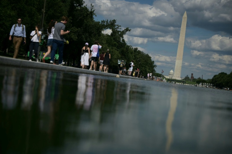 Des promeneurs longent le bassin réfléchissant du Lincoln Memorial après l'achèvement de travaux de rénovation, le 18 juin 2026 à Washington ( AFP / Oliver Contreras )