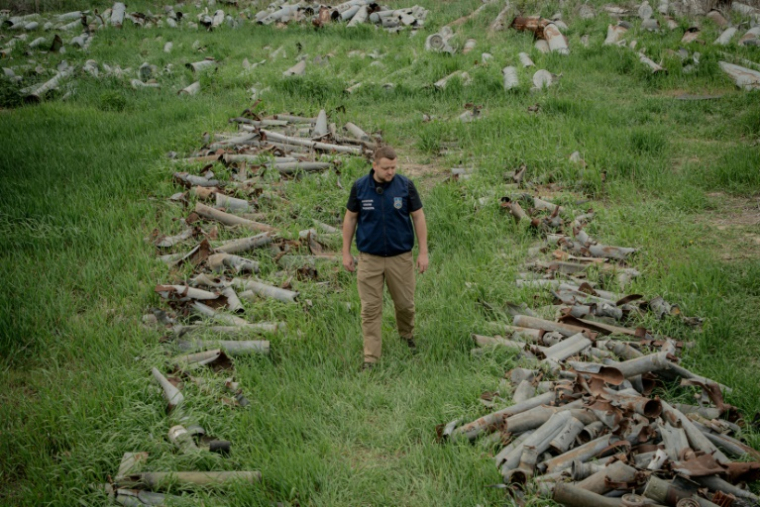 Dmytro Chubenko, porte-parole du parquet de Kharkiv, sur un lieu de stockage d'obus russes tirés sur la région. Le 30 avril 2025  ( AFP / Ivan SAMOILOV )