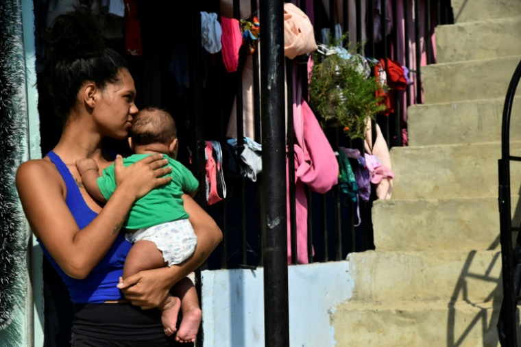 Une femme porte un bébé, à La Fortaleza près de Cucuta, en Colombie, le 9 janvier 2026 ( AFP / Schneyder MENDOZA )