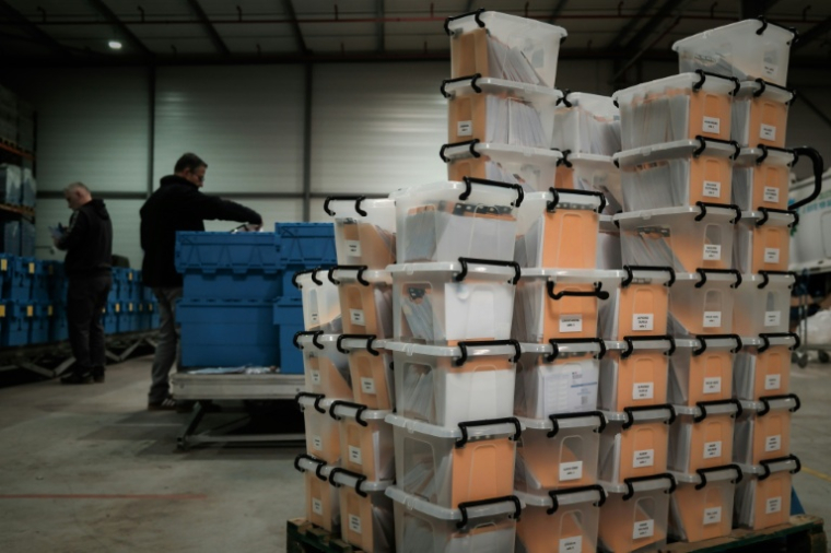 Des cartons contenant des cartes d'électeur non distribuées en attente d'expédition, dans un entrepôt municipal de Bruges, près de Bordeaux, le 12 mars 2026 ( AFP / Philippe LOPEZ )