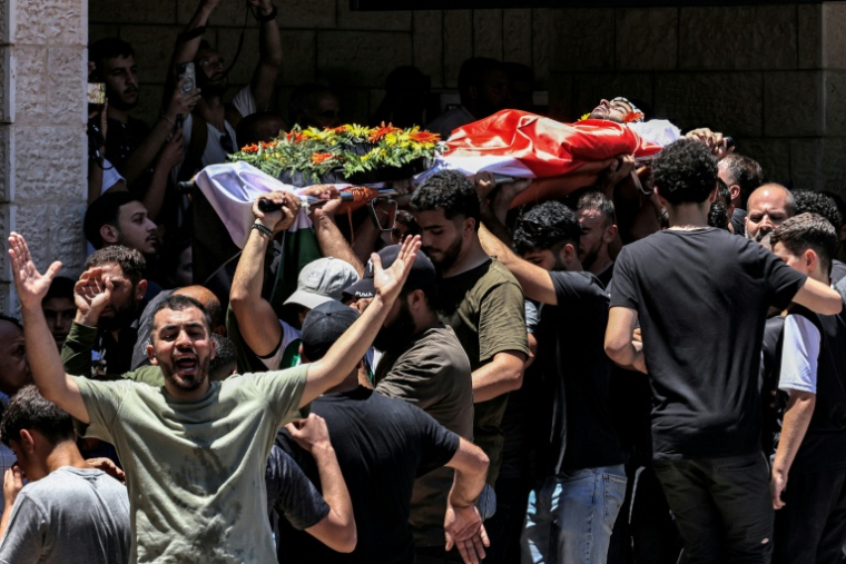 Le corps de Seif Musallet, un Américano-Palestinien de 20 ans, porté par la foule le jour de ses funérailles, à Al-Mazra'ah ash Sharqïyah, en Cisjordanie occupée, le 13 juillet 2025 ( AFP / Zain JAAFAR )