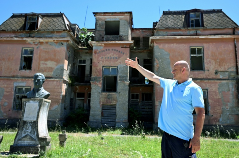 Le journaliste Mustafa Canka  lors d'un entretien avec l'AFP devant le bâtiment administratif des marais salants abandonnés d'Ulcinj, le 14 juin 2026 au Monténégro ( AFP / SAVO PRELEVIC )
