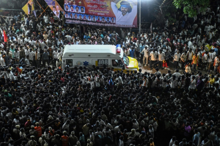Une ambulance transportant des victimes se fraye un chemin à travers la foule après une bousculade qui s'est produite lors d'un rassemblement politique, dans l'État du Tamil Nadu, le 27 septembre 2025 en Inde ( AFP / - )