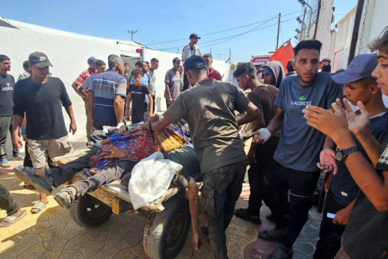 Des Palestiniens transportent des victimes abattues alors qu'elles attendaient des colis alimentaires à un point de distribution géré par la Fondation humanitaire de Gaza (GHF) à Rafah, dans le sud de la bande de Gaza, le 12 juillet 2025 ( AFP / - )