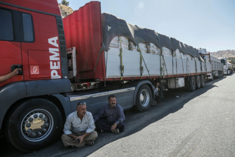 Des chauffeurs de camion iraniens attendent de pouvoir repasser la frontière iranienne dans le district de Penjwen, près de la frontière avec l'Iran, dans la région autonome du Kurdistan irakien, le 21 septembre 2026 ( AFP / Safin HAMID )