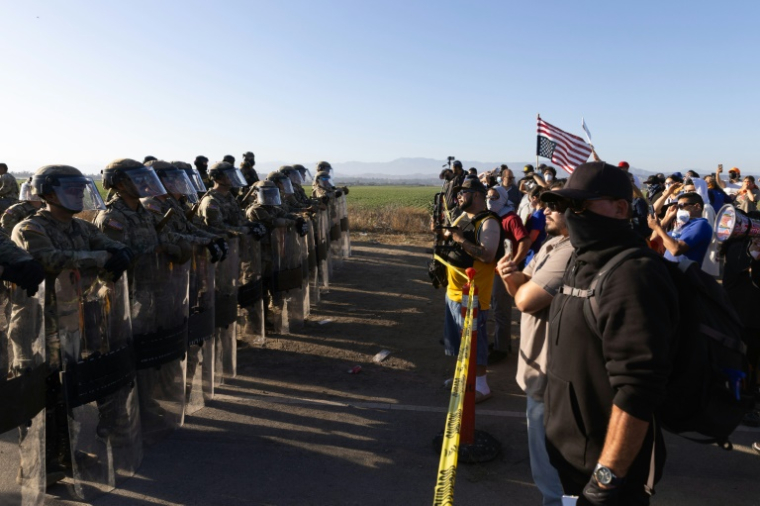 La garde nationale californienne face à des manifestants après une descente de la police de l'immigration près de Los Angeles, le 10 juillet 2025 ( AFP / BLAKE FAGAN )