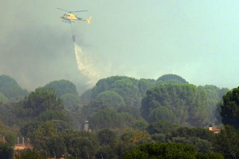 Un hélicoptère bombardier d'eau en action au-dessus d'un feu de forêt à San Martin de Valdeiglesias, à environ 70km à l'ouest de Madrid, le 26 juillet 2026 ( AFP / Cesar MANSO )