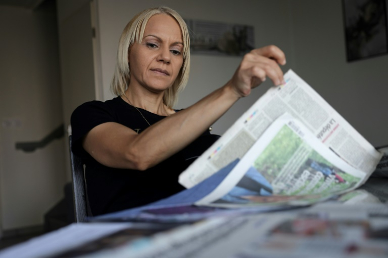 La Marocaine Yasmina Tellal, consulte des coupures de presse, dans le sud-ouest de la France, le 15 août 2025 ( AFP / Valentine CHAPUIS )
