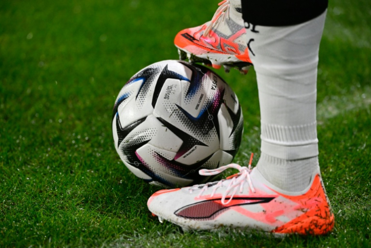 Les crampons d'un joueur et un ballon de football lors d'un match à Metz le 28 novembre 2025 ( AFP / Jean-Christophe VERHAEGEN )