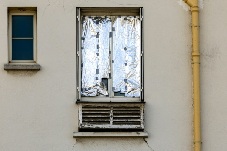 Une fenêtre recouverte d'une couverture de survie à Paris le 20 juillet 2026 ( AFP / JOEL SAGET )