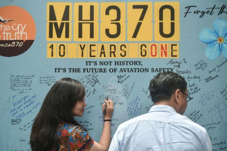 Une femme écrit un message sur un mémorial marquant les 10 ans de la disparition en 2014 du vol MH370, lors d'une cérémonie à Subang Jaya le 3 mars 2024 ( AFP / Arif Kartono )