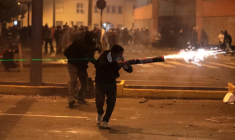 Un manifestant utilise des feux d'artifice contre les policiers anti-émeutes lors d'affrontements qui ont suivi une manifestation contre le président par intérim du Pérou, José Jeri, à Lima, le 15 octobre 2025 ( AFP / CONNIE FRANCE )