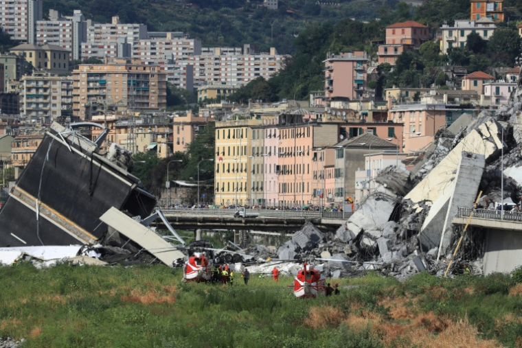 Des secouristes sur le site de l'effondrement du pont autoroutier Morandi à Gênes, le 14 août 2018 en Italie ( AFP / Valery HACHE )