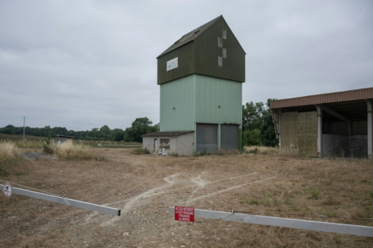 Des fleurs visibles le 16 juin 2026 au pied d'un silo agricole où a été retrouvé le corps de Lyhanna, à  Puycasquier, dans le Gers ( AFP / Ed JONES )