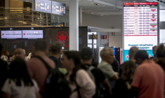 Des voyageurs consultent un panneau d'information sur les vols annulés d'Air Canada à l'aéroport Pierre-Elliott Trudeau à Montréal, au Québec, le 17 août 2025 au Canada ( AFP / ANDREJ IVANOV )