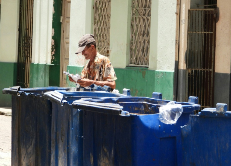 Un homme fouille dans une benne à ordures à La Havane, le 15 juillet 2025 ( AFP / ADALBERTO ROQUE )