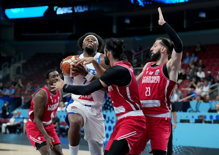 Le capitaine des Bleus Guerschon Yabusele pris en étau dans la défense géorgienne, lors des 8e de finale de l'Euro de basket, le 7 septembre 2025 à Riga ( AFP / Gints Ivuskans )