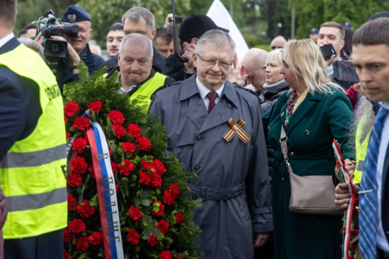 L'ambassadeur de Russie en Pologne Sergueï Andreïev (c) dépose une gerbe de fleurs au mausolée des soldats soviétiques à Varsovie, le 9 mai 2025 en Pologne ( AFP / Wojtek RADWANSKI )