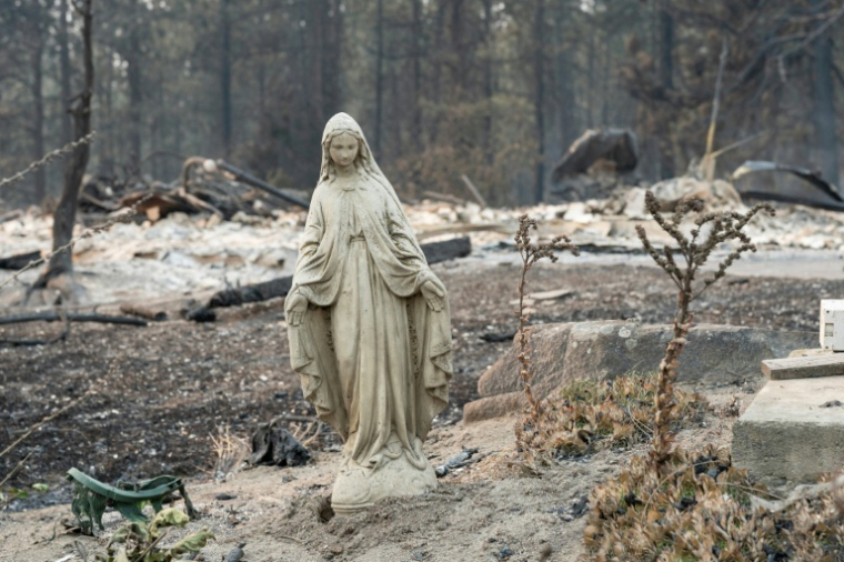 Une statue de la Vierge Marie près des ruines d'une maison détruite par le feu à Spokane (Etats-Unis) le 2 août 2026 ( AFP / Erick Doxey )