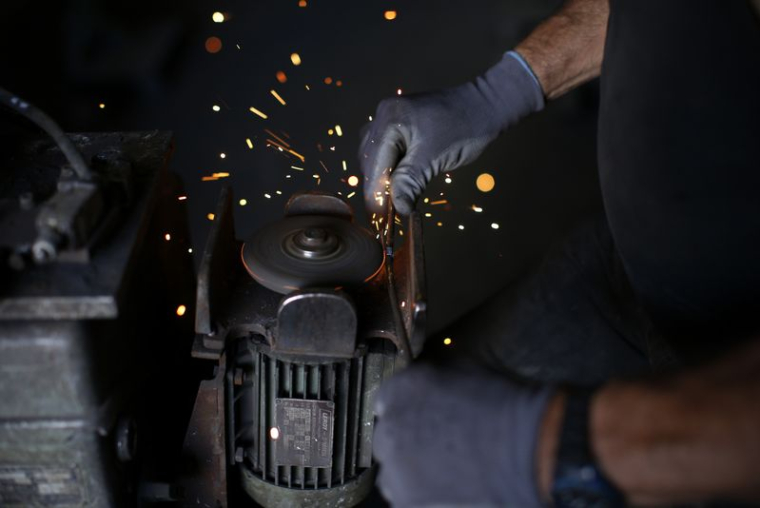 Un employé travaille sur une machine dans la dernière usine de clous encore en activité en France