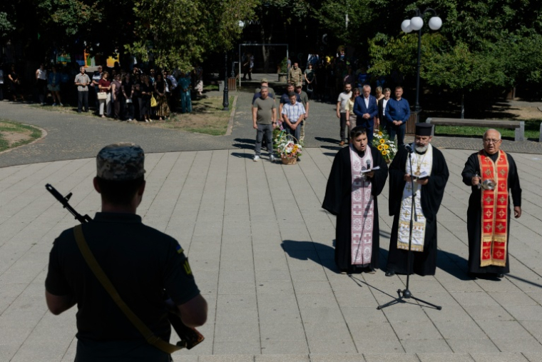 Un militaire devant des prêtres lors d'une cérémonie en hommage aux soldats ukrainiens à Berehove, dans la région de Transcarpatie, à l'ouest de l'Ukraine, le 28 août 2026 ( AFP / Tetiana DZHAFAROVA )