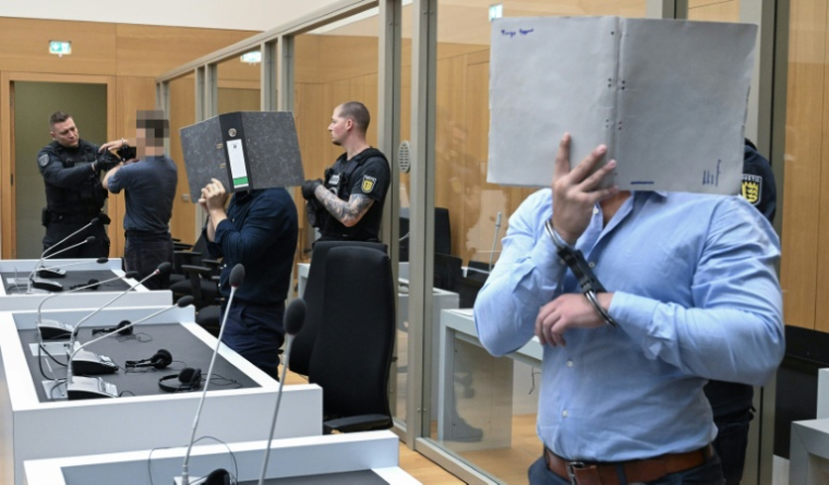 (g-d) Trois ressortissants Ukrainiens, Daniil B., Vladyslav T. et Yevhen B., poursuivis pour avoir aidé les services secrets russes à des fins de sabotages à l'explosif, attendent leur verdict au tribunal régional de Stuttgart-Stammheim, dans le sud de l'Allemagne, le 18 août 2026 ( AFP / THOMAS KIENZLE )