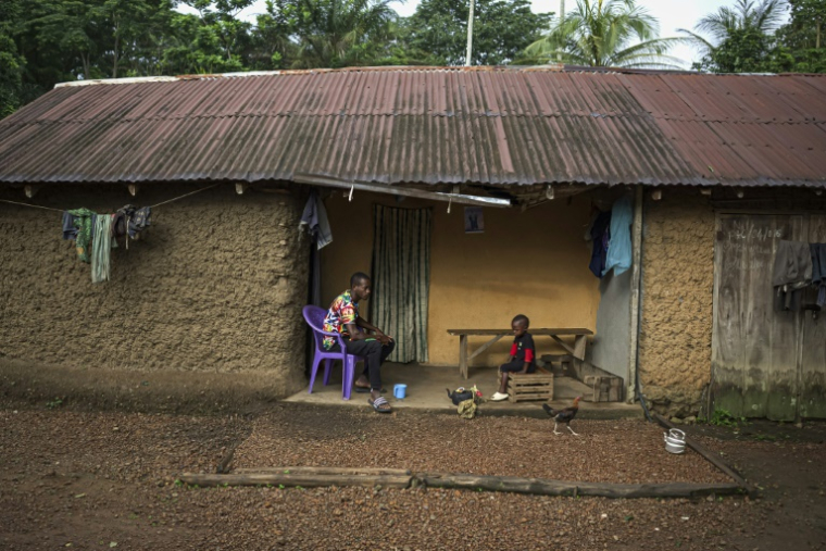 Un habitant est assis à l'extérieur de sa maison sur l'île de Tiwai le 1er juillet 2025, un trésor de biodiversité dans le sud-est de la Sierra Leone. Le complexe de Gola-Tiwai - composé de la réserve de Tiwai et du parc national de la forêt tropicale de Gola - est entré le 13 juillet 2025 au patrimoine mondial de l'humanité à l'issue d'un vote lors de la 47ème session du Comité du patrimoine mondial de l'Unesco ( AFP / Saidu BAH )