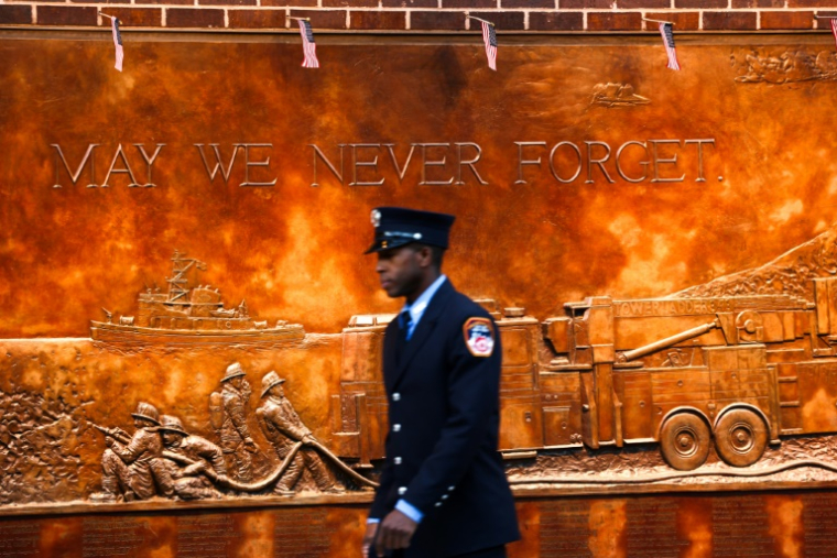 Un pompier passe devant un mur commémoratif du FDNY dans la zone du World Trade Center avant la cérémonie du 24e anniversaire des attentats terroristes du 11 septembre 2001, à New York, le 11 septembre 2025 ( AFP / CHARLY TRIBALLEAU )
