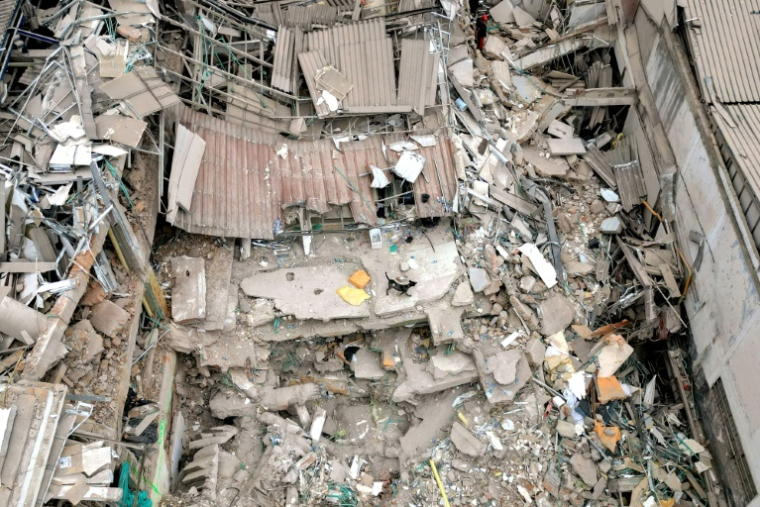 Une vue aérienne montre un chien marchant au milieu des décombres d'un bâtiment effondré après un séisme de magnitude 7,4 à Pereira, en Colombie, le 15 août 2026 ( AFP / Luis ACOSTA )