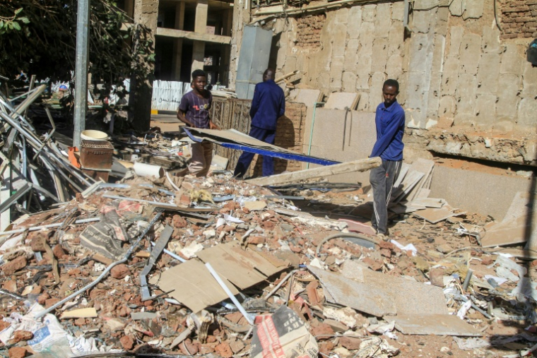 Des ouvriers de la construction s'affairent au milieu des débris, le 17 janvier 2025 à Khartoum ( AFP / Ebrahim HAMID )