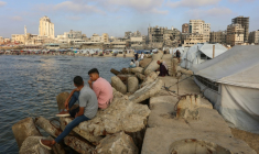 Des Palestiniens se rassemblent sur la plage de Gaza-ville, en bordure de tentes intallées par des déplacés, le 8 juin 2025 ( AFP / Omar AL-QATTAA )