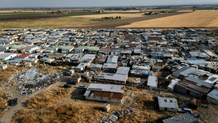 The shanty town spreads out between the disused runways of a former military airfield. ( AFP / Tiziana FABI )