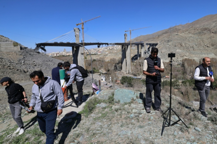 Des journalistes rassemblés devant le pont B1 détruit par une frappe américaine, le 3 avril 2026 à Karaj, en Iran ( AFP / ATTA KENARE )