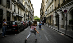 Des enfants jouent au tennis dans une rue de Paris le 21 avril 2020, en plein confinement lié au Covid-19  ( AFP / Christophe ARCHAMBAULT )