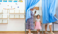 Une femme vote avec sa fille pour la présidentielle roumaine, le 4 mai 2025 à Ciocanesti ( AFP / Mihai Barbu )