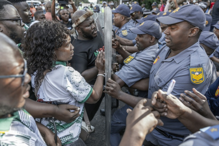 Des membres du mouvement antimigrants "March and March" face à des policiers, à Durban, dans l'est de l'Afrique du Sud, le 21 mai 2026 ( AFP / RAJESH JANTILAL )