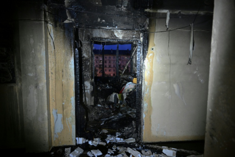 L'entrée d'un appartement carbonisé dans un immeuble résidentiel endommagé par des frappes massives de drones et de missiles russes sur Kiev, le 10 octobre 2025 en Ukraine ( AFP / Genya SAVILOV )