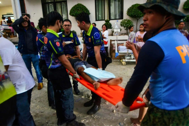 Les policiers et les secouristes transportent une personne blessée  à l'hôpital dans la ville de Bogo, province de Cebu, au centre des Philippines, le 1er octobre 2025, après qu'un puissant séisme ( AFP / Alan Tangcawan )