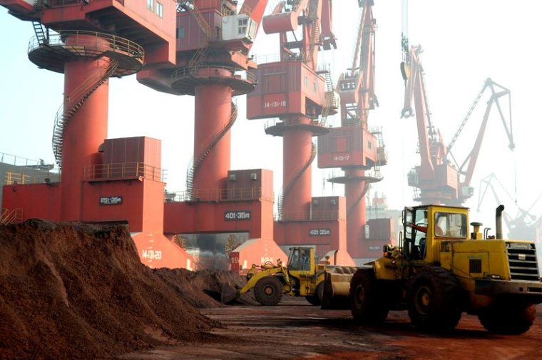 Des ouvriers transportent de la terre contenant des terres rares destinées à l'exportation dans un port à Lianyungang