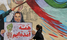 Une Iranienne passe devant une fresque anti-américaine et anti-israélienne sur laquelle on peut lire "Pour la révolution, nous sommes tous venus", dans la capitale Téhéran, le 10 mai 2026 ( AFP / ATTA KENARE )