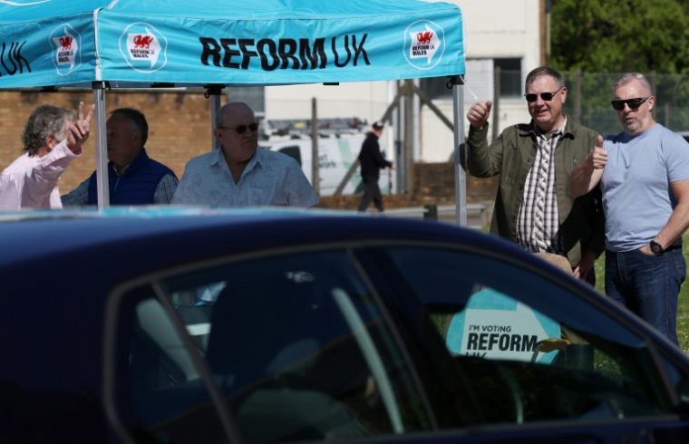 Des militants du parti Reform à Merthyr Tydfil, au Pays de Galles, le 24 avril 2026, pendant la campagne électorale  ( AFP / Darren Staples )