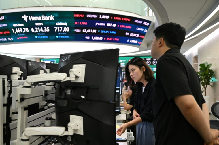 Des cambistes devant des écrans au siège de la Hana Bank à Séoul le 28 juillet 2026. ( AFP / Jung Yeon-je )